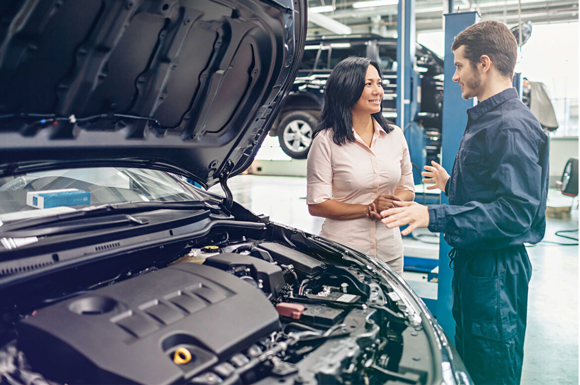 A female car owner talking to a mechanic at an automotive care business